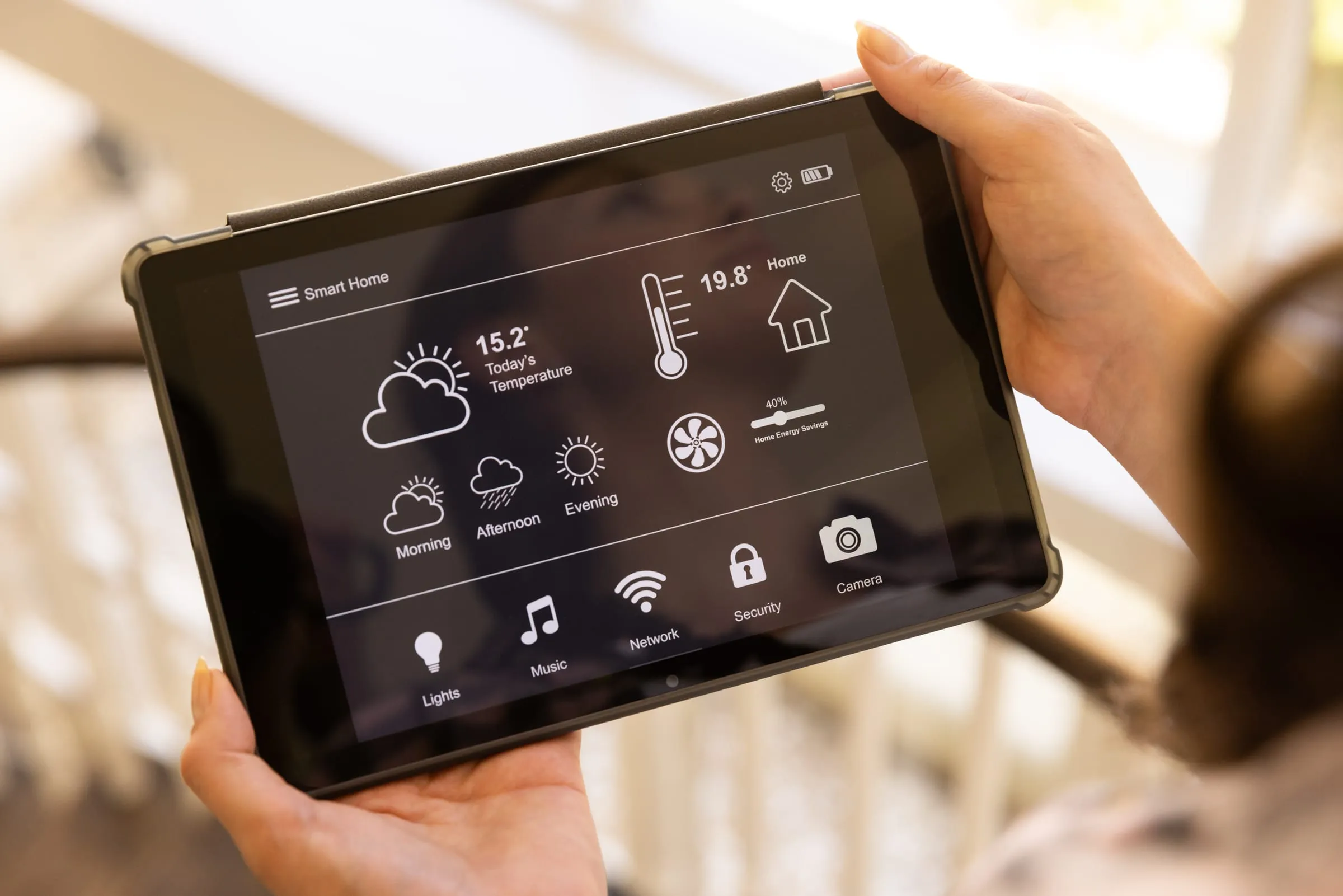 Person holding a tablet with a smart-home interface